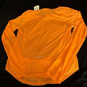 Under Armour heat gear top with zipper on the back for small items.  No returns